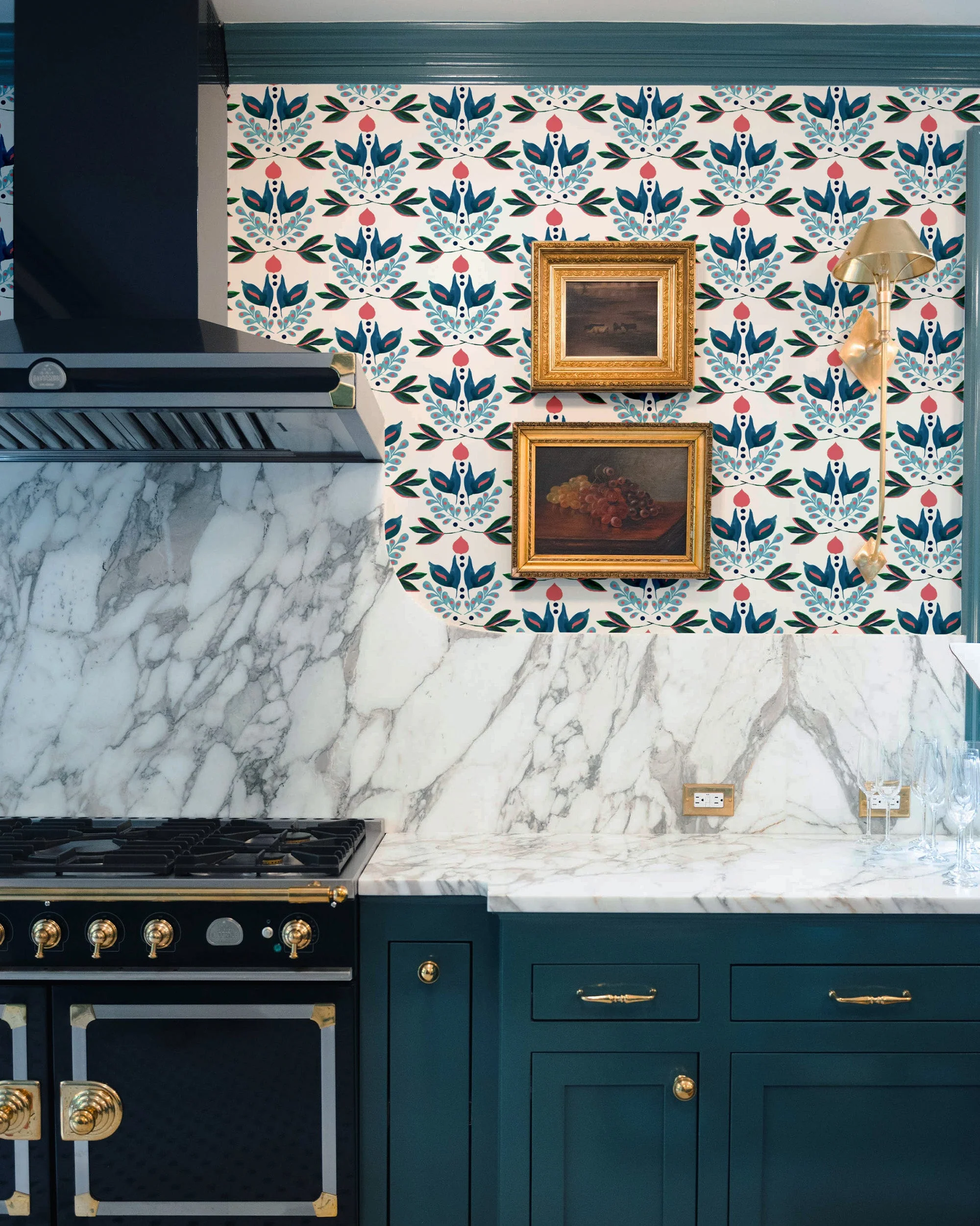 Teal kitchen with marble backsplash, brass accents, and folk floral feature wallpaper