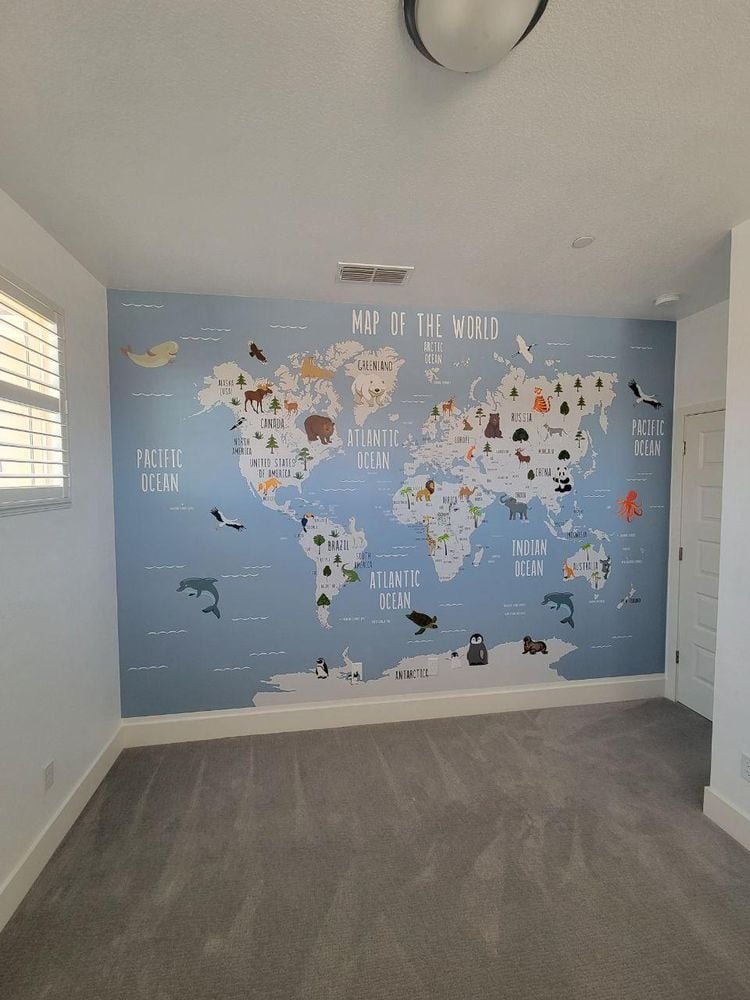 Children's room with a soft blue world-map mural feature wall