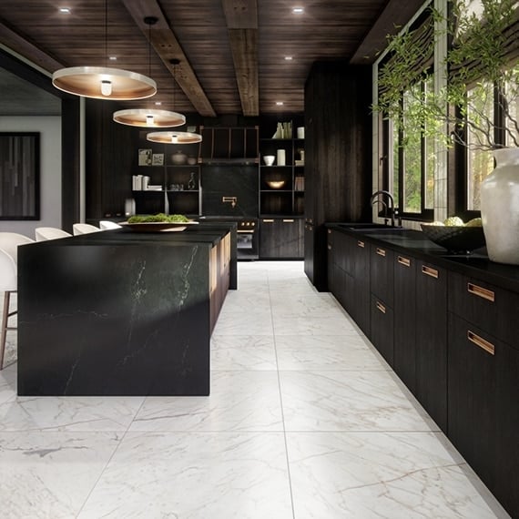 Dramatic kitchen with dark veined marble island and brass fixtures